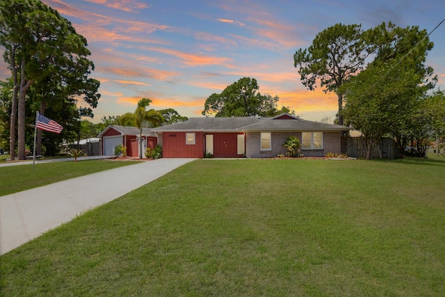 ranch-style home with a garage and a yard