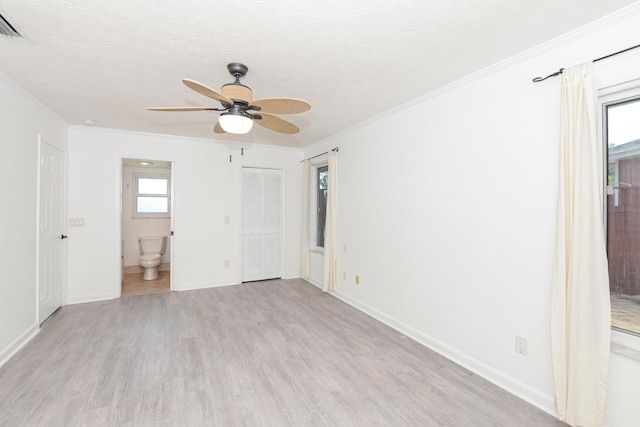 unfurnished bedroom with ceiling fan, ensuite bathroom, light wood-type flooring, a textured ceiling, and ornamental molding