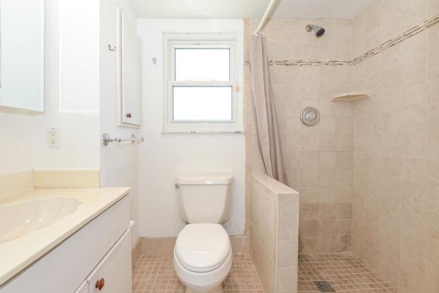 bathroom featuring tile patterned floors, vanity, toilet, and curtained shower