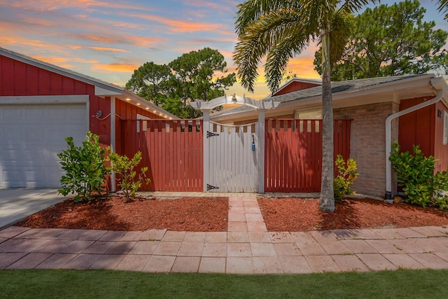 gate at dusk featuring a garage