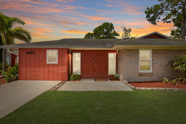 ranch-style home with a lawn