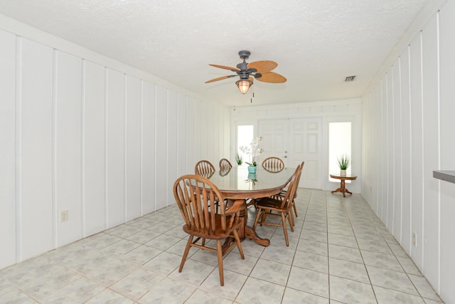 tiled dining area featuring ceiling fan and a textured ceiling