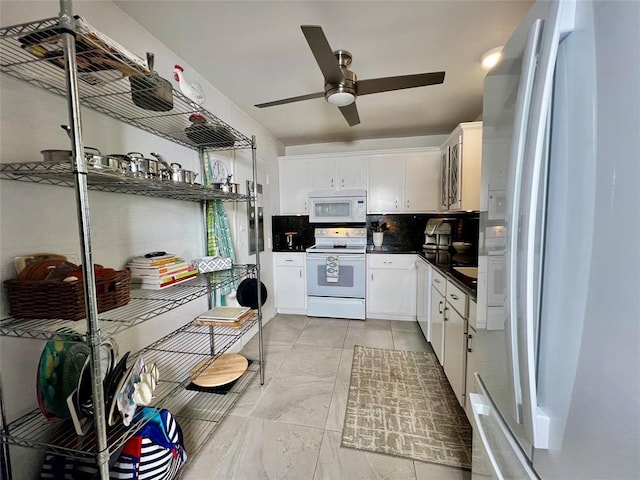 kitchen with white appliances, white cabinetry, ceiling fan, and backsplash