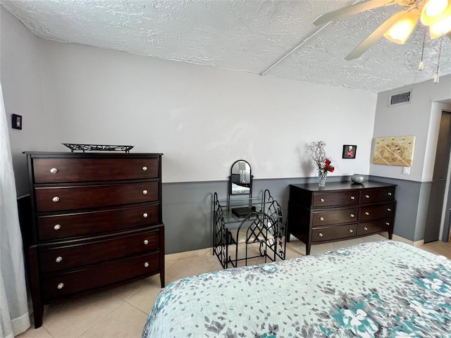 tiled bedroom with a textured ceiling and ceiling fan