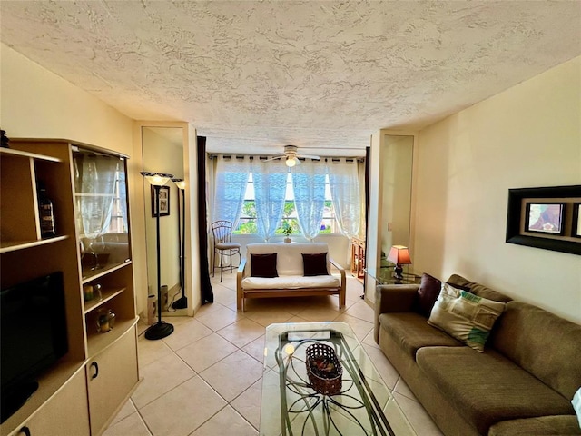 living room featuring ceiling fan, light tile patterned floors, and a textured ceiling