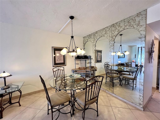 dining area featuring light tile patterned floors, a textured ceiling, and an inviting chandelier