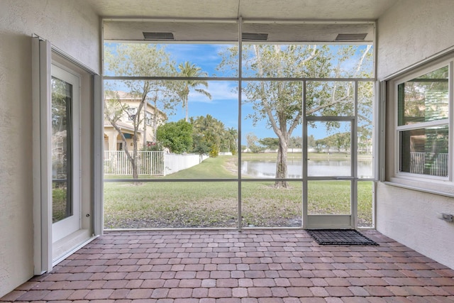 unfurnished sunroom with a water view