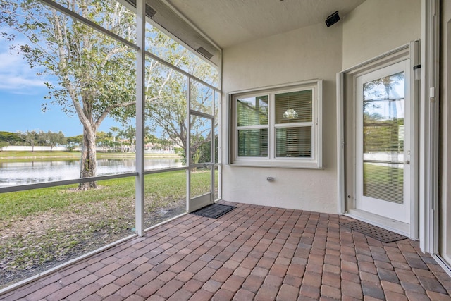 unfurnished sunroom featuring a water view