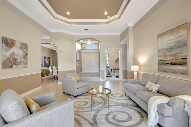 tiled living room featuring a raised ceiling and ornamental molding