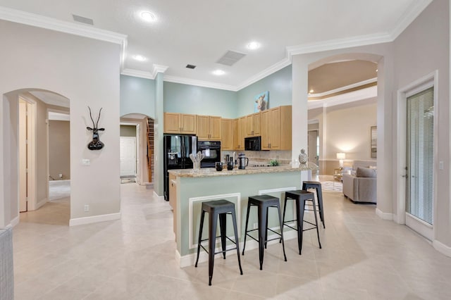 kitchen with a kitchen bar, tasteful backsplash, ornamental molding, light stone counters, and black appliances