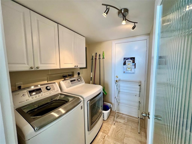 laundry room featuring washer and clothes dryer and cabinets