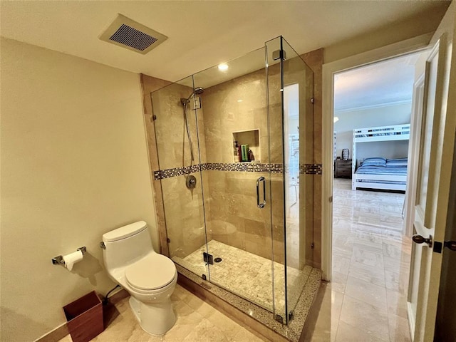 bathroom featuring a shower with door and toilet