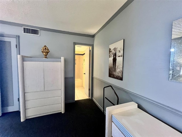 bedroom with dark carpet and a textured ceiling