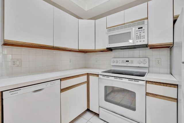 kitchen with white cabinetry, white appliances, decorative backsplash, and light tile patterned flooring