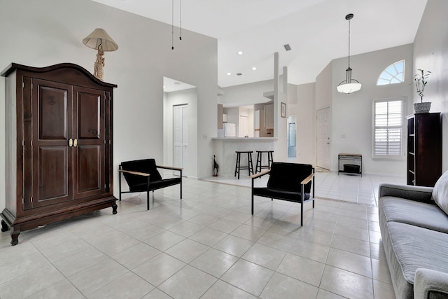 living area with light tile patterned flooring and a towering ceiling
