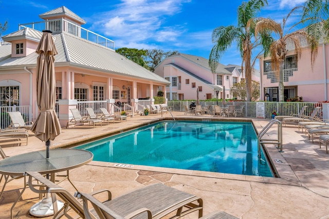 community pool featuring a patio area, a residential view, and fence