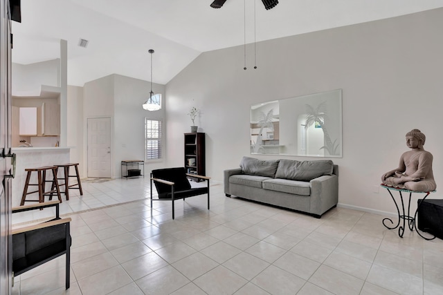 living area with light tile patterned floors, visible vents, ceiling fan, and high vaulted ceiling
