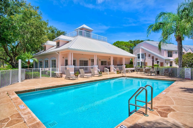 community pool with fence and a patio area