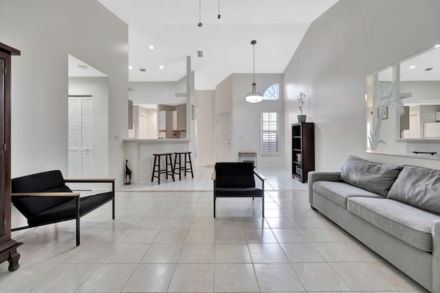 living area featuring light tile patterned floors, a high ceiling, and recessed lighting