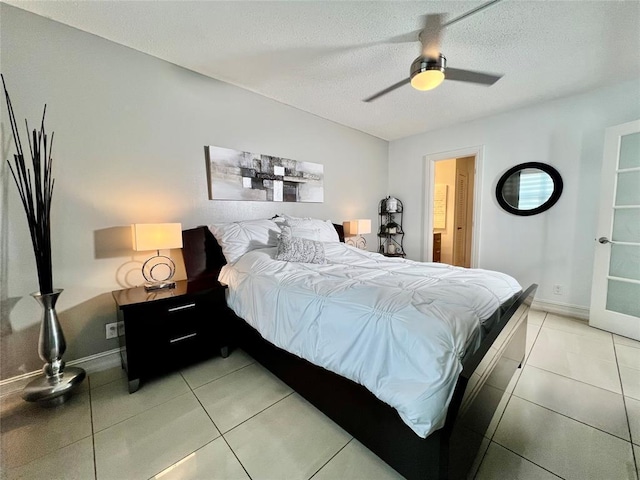 tiled bedroom featuring ceiling fan and a textured ceiling