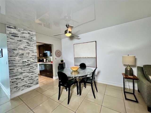 dining space with ceiling fan and light tile patterned flooring