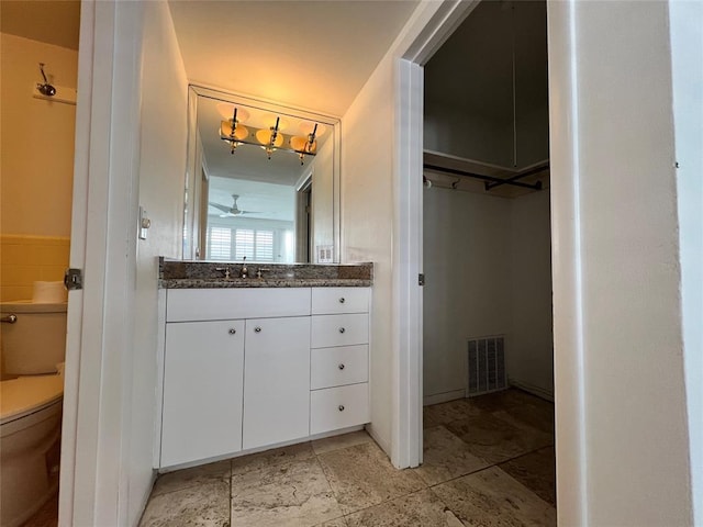 bathroom featuring vanity, toilet, and ceiling fan