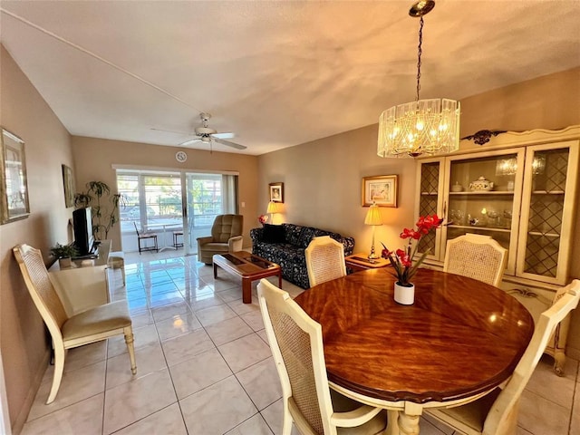 tiled dining area featuring ceiling fan with notable chandelier