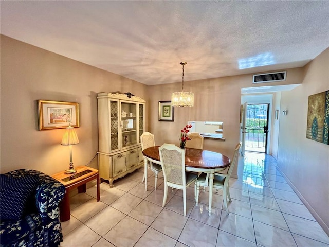 dining room with a textured ceiling, a notable chandelier, and light tile patterned flooring