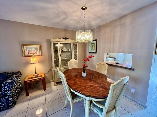 tiled dining space with a chandelier