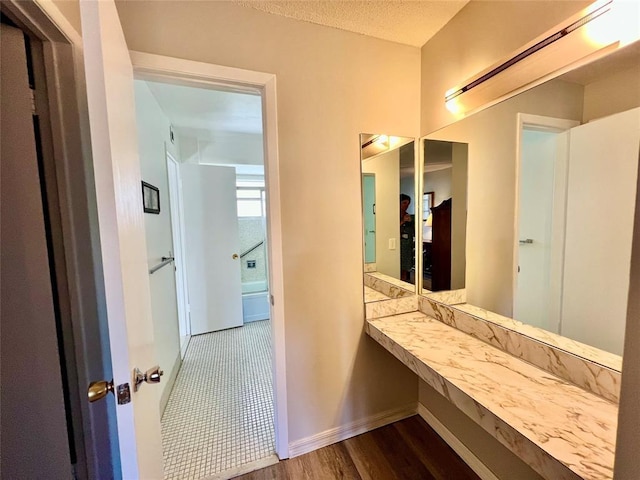 bathroom featuring a textured ceiling and hardwood / wood-style flooring