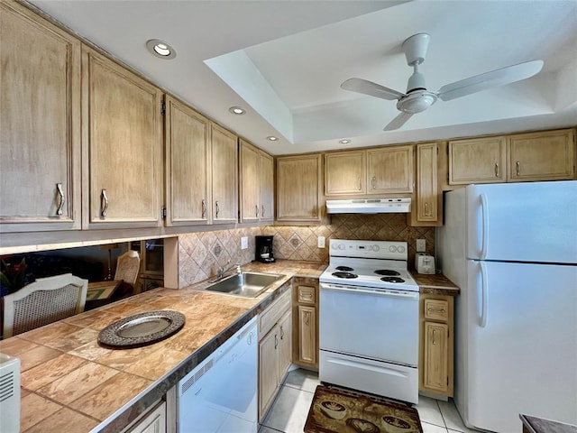 kitchen with white appliances, sink, ceiling fan, light tile patterned floors, and a tray ceiling