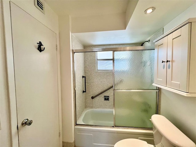 bathroom featuring toilet and enclosed tub / shower combo