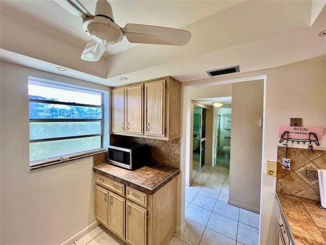 kitchen featuring light brown cabinets, tasteful backsplash, ceiling fan, and light tile patterned flooring