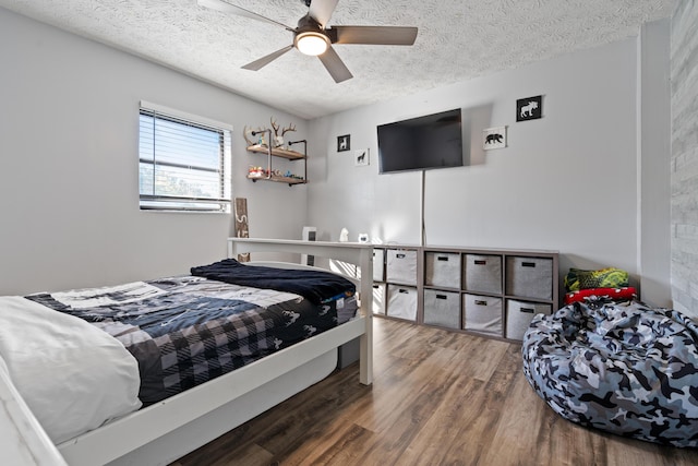 bedroom with ceiling fan, wood-type flooring, and a textured ceiling