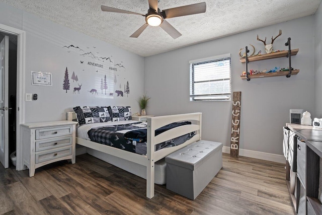 bedroom with ceiling fan, dark hardwood / wood-style flooring, and a textured ceiling