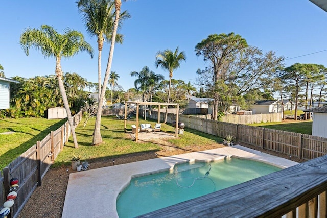 view of swimming pool with a patio area, a yard, and a shed