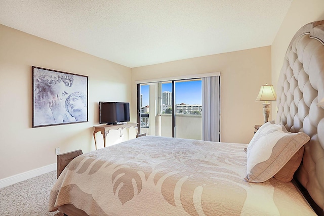 bedroom with access to exterior, a textured ceiling, and carpet flooring