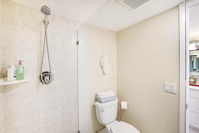 bathroom with toilet and a tile shower