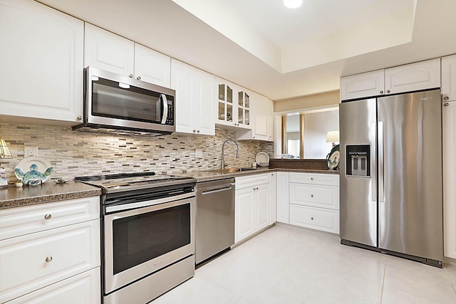 kitchen featuring decorative backsplash, sink, white cabinets, and stainless steel appliances