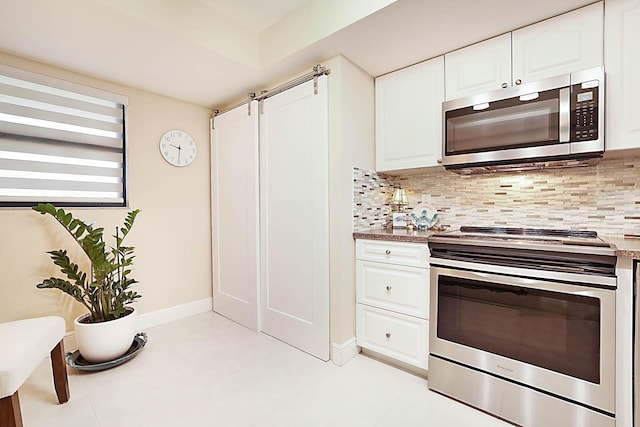 kitchen with light tile patterned floors, white cabinetry, appliances with stainless steel finishes, and tasteful backsplash