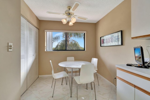 dining room with ceiling fan and a textured ceiling