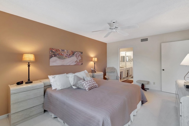 bedroom with light carpet, ceiling fan, and ensuite bathroom