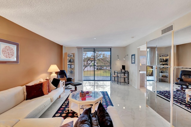 living room featuring a wall of windows and a textured ceiling