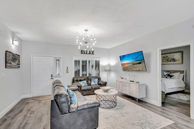 living room featuring light hardwood / wood-style floors and a notable chandelier