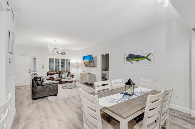 dining space featuring a notable chandelier and light hardwood / wood-style flooring