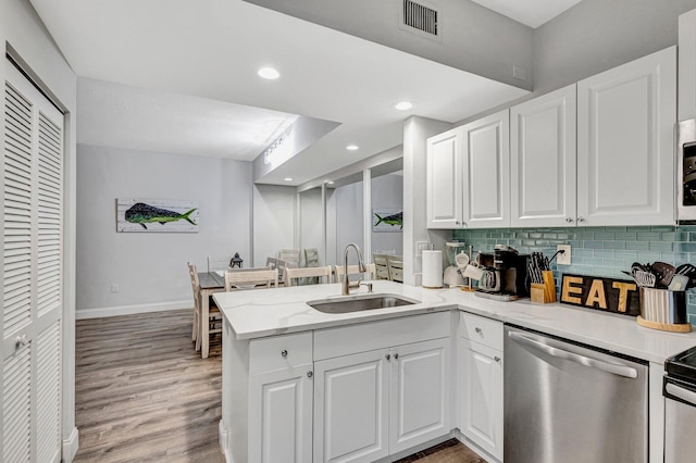 kitchen featuring dishwasher, kitchen peninsula, decorative backsplash, white cabinets, and sink