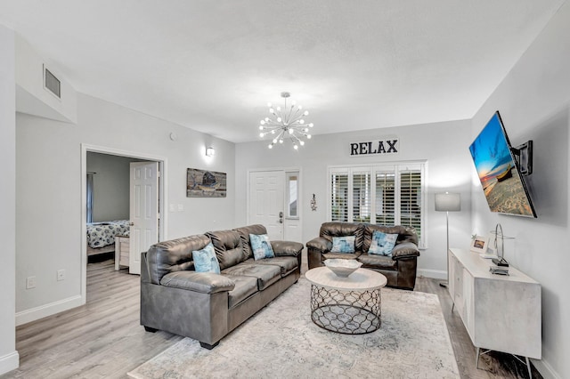 living room featuring an inviting chandelier and light wood-type flooring