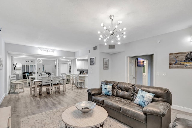 living room with light hardwood / wood-style flooring and a chandelier