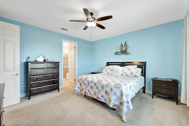 bedroom with ensuite bathroom, ceiling fan, and light colored carpet