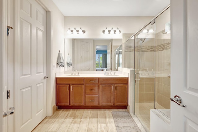 bathroom featuring vanity, wood-type flooring, and walk in shower